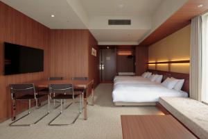 a hotel room with a bed and a desk and a television at Candeo Hotels Osaka Shinsaibashi in Osaka