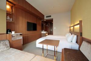 a hotel room with a bed and a table at Candeo Hotels Osaka Shinsaibashi in Osaka