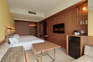 a hotel room with a bed and a tv at Candeo Hotels Osaka Shinsaibashi in Osaka
