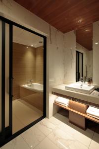 a bathroom with a tub and a sink at Candeo Hotels Osaka Shinsaibashi in Osaka
