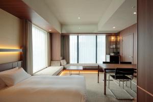 a bedroom with a bed and a desk and a table at Candeo Hotels Osaka Shinsaibashi in Osaka