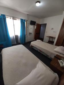 um quarto de hotel com duas camas e uma mesa em Residencial Ski em Esquel