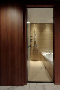 a bathroom with a shower and a tub and a sink at Candeo Hotels Osaka Shinsaibashi in Osaka