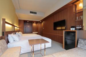 a hotel room with two beds and a tv at Candeo Hotels Osaka Shinsaibashi in Osaka