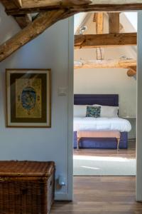a bedroom with a bed with a bench in it at 1 Rue Pasquet - Double room in main house in Beaumont-du-Périgord
