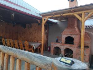 a patio with a brick fireplace with a table and chairs at Casa Diana Rasnov in Râşnov