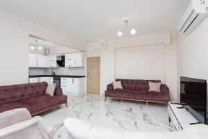 a living room with two couches and a tv at Villa Azalea 1 in Ortaca