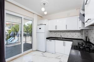 a kitchen with white cabinets and a large window at Villa Azalea 1 in Ortaca