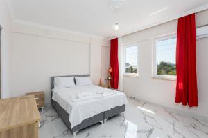 a white bedroom with a bed with red curtains at Villa Azalea 1 in Ortaca
