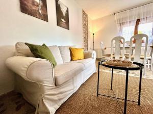 Una sala de estar con un sofá blanco y una mesa. en Casa Rural, “El Andador”, en El Hoyo de Pinares