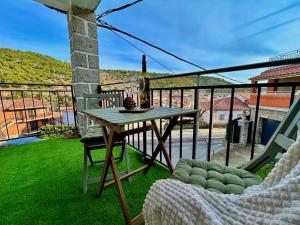 een tafel en een stoel op een balkon met uitzicht bij Casa Rural, “El Andador” in Hoyo de Pinares