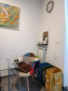 a room with a chair and a clock on the wall at Wake'n Bake Affittacamere in Genova