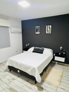 een slaapkamer met een groot bed met een zwarte muur bij Luxury Apartment Posadas 2 in Posadas