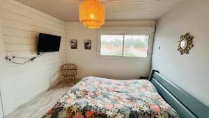 a bedroom with a bed and a flat screen tv at Maison d'architecte de la Parée in Saint-Jean-de-Monts