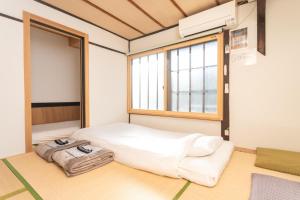 a room with a bed and a window at GuestHouse OneWorld Shijo四条京町屋 in Kyoto