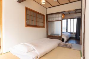 une chambre avec un grand lit et un miroir dans l'établissement GuestHouse OneWorld Shijo四条京町屋, à Kyoto