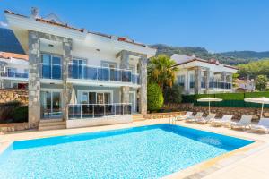 a villa with a swimming pool in front of a house at Golden Heights 5 in Oludeniz