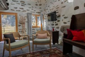 a living room with two chairs and a fireplace at Verzasca Lodge Ofelia in Sonogno