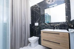 a bathroom with a sink and a toilet and a mirror at CF Luxury House in Lido di Ostia