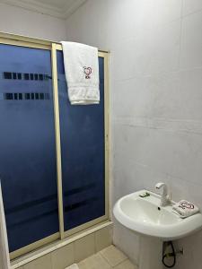 ein Bad mit einer Dusche, einem Waschbecken und einem Handtuch in der Unterkunft Break or Makeup in Lekki
