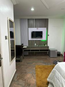 ein Hotelzimmer mit einem TV und einem Schlafzimmer in der Unterkunft Break or Makeup in Lekki
