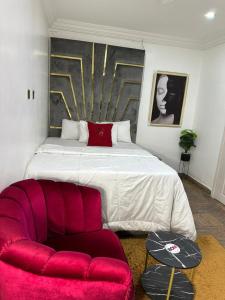 ein Schlafzimmer mit einem großen Bett und einem roten Sofa in der Unterkunft Break or Makeup in Lekki