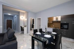 a living room with a dining table and a kitchen at CF Luxury House in Lido di Ostia