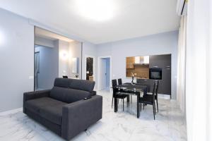 uma sala de estar com um sofá e uma mesa em CF Luxury House em Lido di Ostia