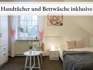 um quarto com uma cama, uma cadeira e uma mesa em Blumenvilla 8 mit Sauna und Garten em Schneverdingen