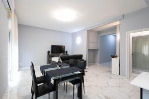 a dining room with a black table and chairs at CF Luxury House in Lido di Ostia