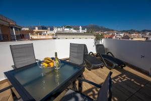 a table with a bowl of fruit on a balcony at Apartamentos Kronox in Nerja