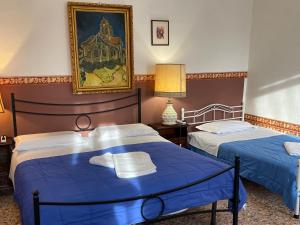 ヴェネツィアにあるPrincess Guest House Canal Viewのブルーシーツ付きの客室内のベッド2台