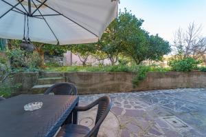a table with an umbrella on a patio at Appartamenti La Marina - Goelba in Marciana Marina