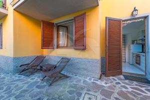 two chairs sitting on a patio outside of a house at Appartamenti La Marina - Goelba in Marciana Marina +3 photos