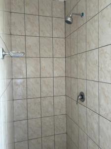 a shower with a shower head in a bathroom at TT’s self-catering apartments in Qumbu