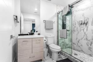 a bathroom with a toilet and a glass shower at Luxurious Apartment in Downtown Dallas 2BR/1 BATH in Dallas