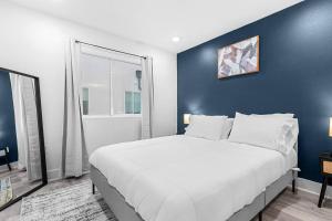 a bedroom with a large bed with a blue wall at Luxurious Apartment in Downtown Dallas 2BR/1 BATH in Dallas