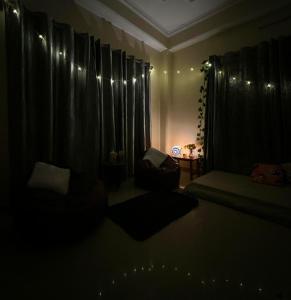 een donkere kamer met een bed en zwarte gordijnen bij Zen Homezz in Shimla