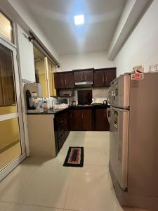 uma cozinha com armários de madeira e um frigorífico de aço inoxidável em Skylar apartment em Kalubowila West