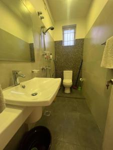 La salle de bains est pourvue d'un lavabo blanc et de toilettes. dans l'établissement Skylar apartment, à Kalubowila West
