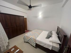 - une chambre avec un lit et un ventilateur de plafond dans l'établissement Skylar apartment, à Kalubowila West