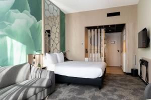 een hotelkamer met een bed en een bank bij Otium Hotel Roosendaal in Roosendaal