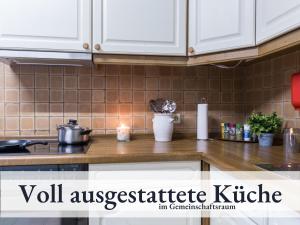 a kitchen counter with white cabinets and a candle at Blumenvilla 9 mit Sauna und Garten in Schneverdingen