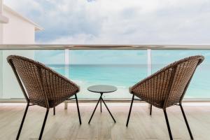 due sedie e un tavolo davanti a una finestra di The Oceanfront by Casa Paraiso a Cancún