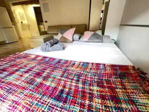 a bed with a colorful blanket on it at APARTANENTO LOFT LAUREL coqueto con Wifi y aire in Logroño