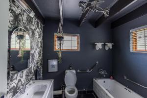 a bathroom with a tub and a toilet and a sink at The Red Door in Clarens