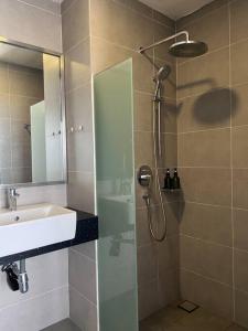 a bathroom with a shower with a sink and a glass shower door at Studio apartment with seaview in George Town