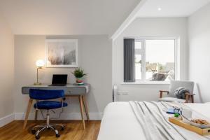 a white bedroom with a desk and a bed at Sea Breeze - Pebbles in Bournemouth