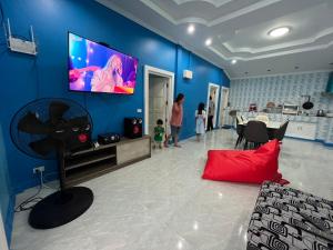 a living room with a flat screen tv on a blue wall at บ้านกลางหุบเขา แก่งกระจาน in Kaeng Krachan