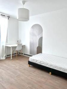 a bedroom with a bed and a table and a desk at Le Phoenix, proche stations ski et Campus Univers. in Gières